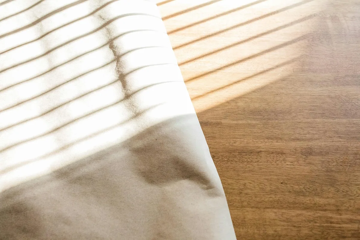 Close-up of smooth cotton sheet fabric in striped sunlight